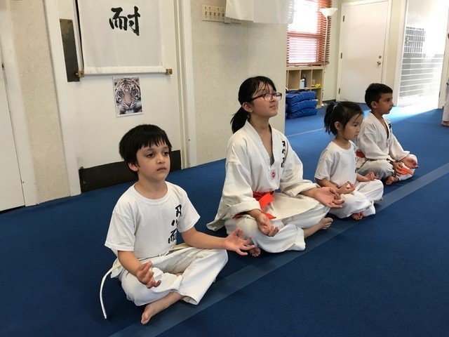 Children practicing martial arts meditation